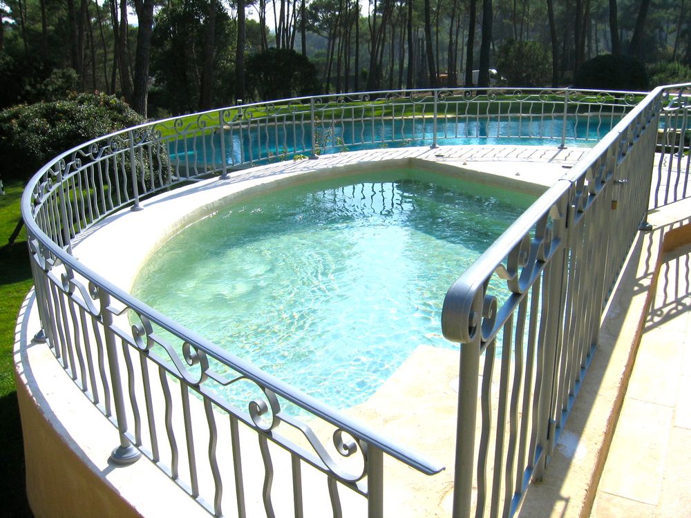 Garde-corps métallique courbe réalisé sur mesure autour d’une piscine