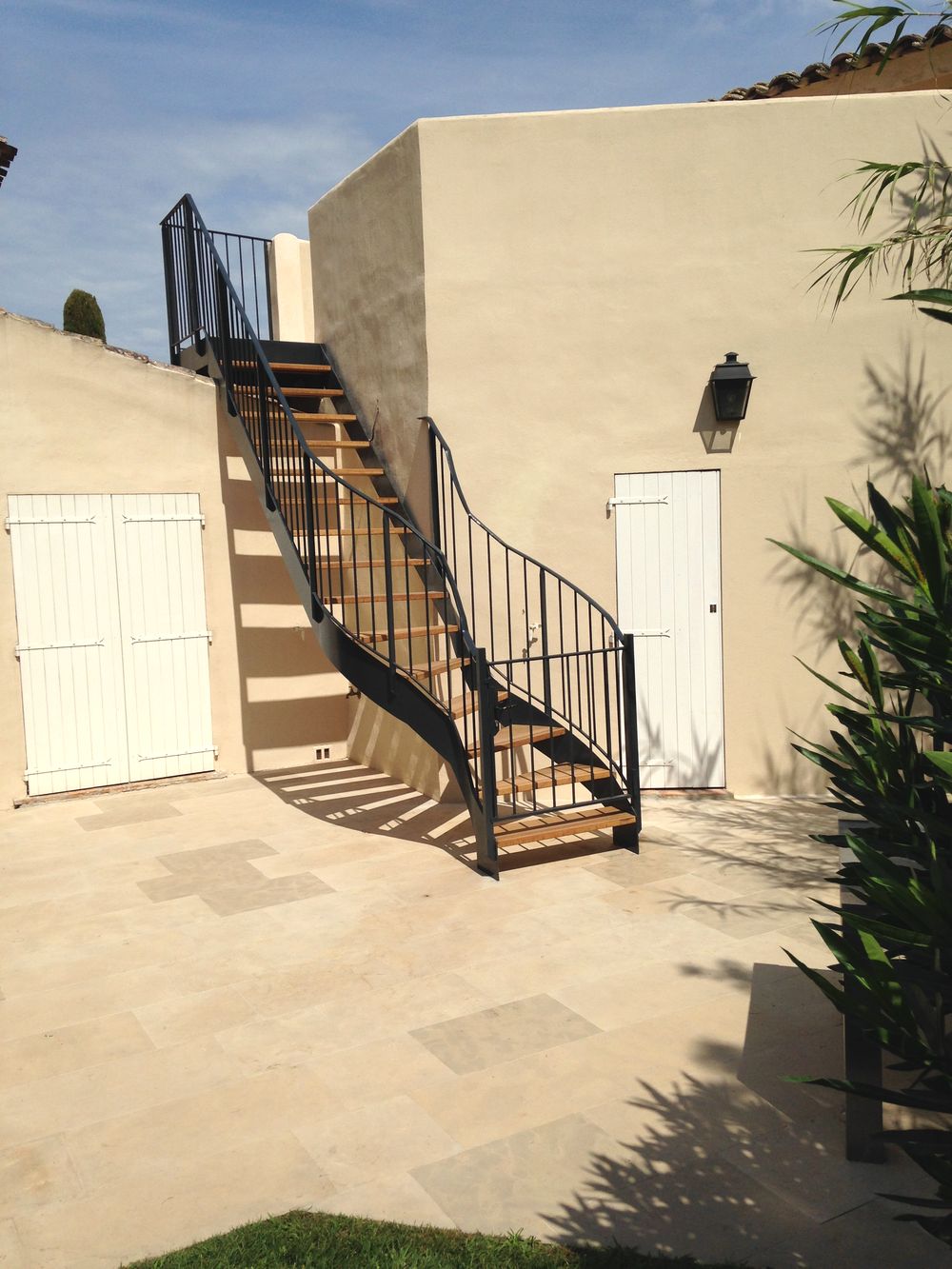 Escalier extérieur en acier avec marches en bois installé dans une villa